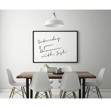 Eetkamer met houten tafel, witte stoelen en een ingelijste afbeelding aan de muur.