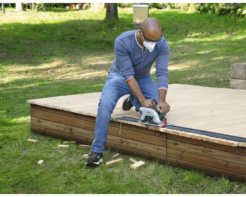 Man zaagt houten terras met cirkelzaag