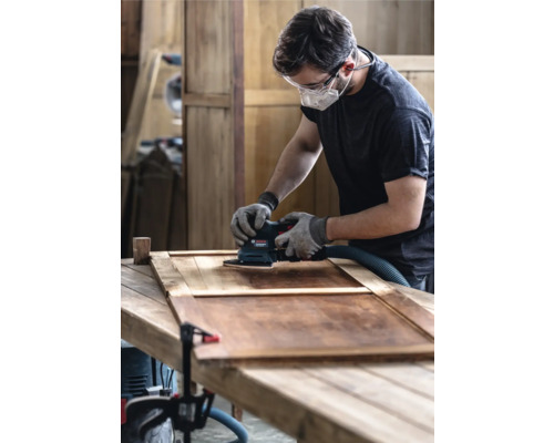 Man schuurt hout met een vlakschuurmachine