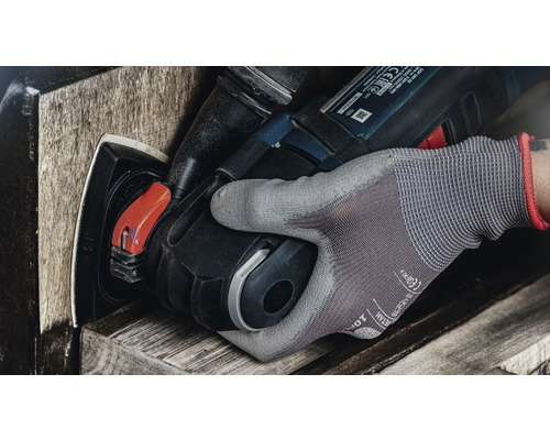 Een hand met werkhandschoen bedient een elektrisch gereedschap voor het schuren van hout.