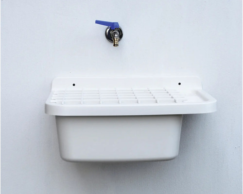 Spoelbak van kunststof met kraan aan de muur gemonteerd