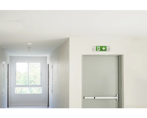 Gang met nooduitgangbord en deur met paniekstang