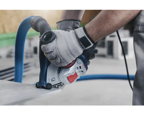 Man gebruikt muurfrees met stofafzuiging om steen te snijden