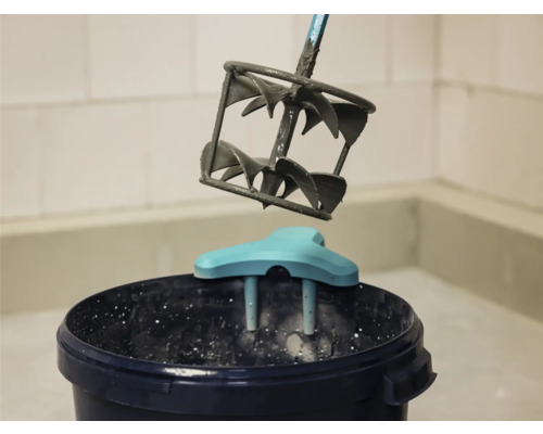 Mortelmixer boven een emmer met mortel