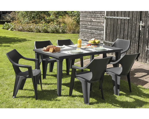 Tuinscene met eettafel en zes stoelen op gazon