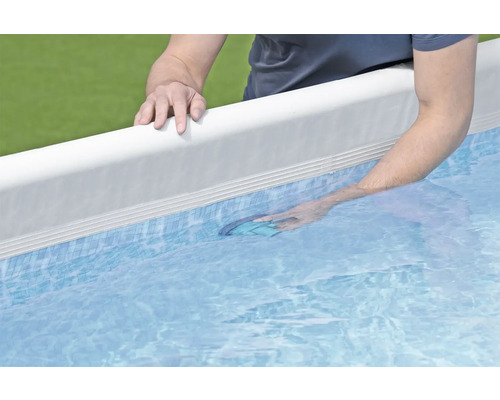 Man maakt zwembad schoon met bodemschepnet