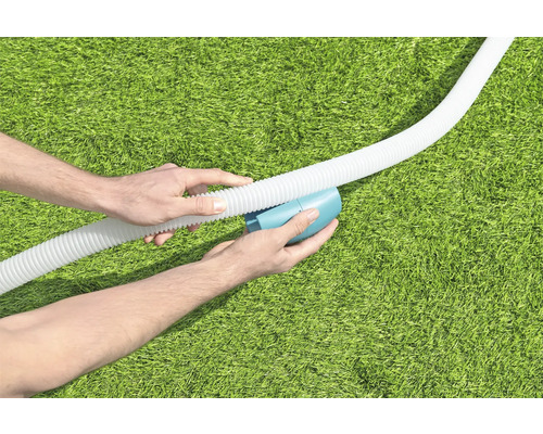 Persoon verbindt zwembadslang met reinigingsapparaat op gazon