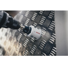 Boormachine met gatenzaag boort in metaal