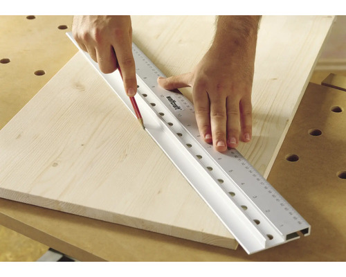 Persoon die met een potlood een lijn trekt langs een Wolfcraft liniaal op een houten plank