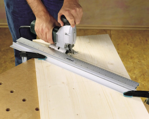 Ambachtsman gebruikt decoupeerzaag met geleiderail op hout