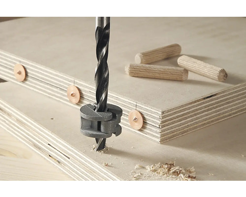 Houtboor boort gat in houten plank met deuvels en deuvelmal