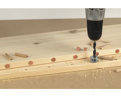 Houten planken worden verbonden met een boormachine, pluggen en hulzen.