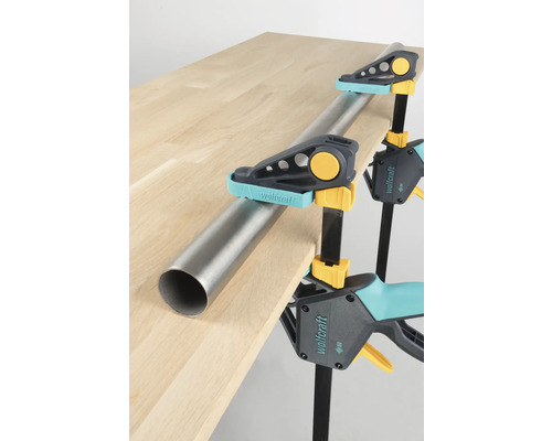 Pijpklemmen houden metalen buis vast op houten tafel