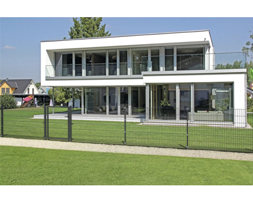Modern huis met grote tuin en metalen hek