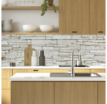 Moderne keuken met stenen muur, spoelbak en houten elementen.