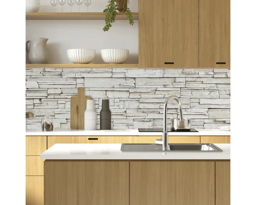 Moderne keuken met stenen muur, spoelbak en houten elementen.