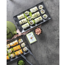 Twee schalen Uramaki sushi, gember, zeewier en een theepot op een tafel