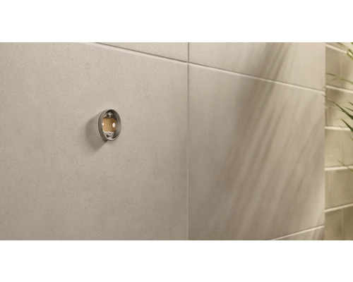 Metalen toiletpapierhouder aan een badkamermuur