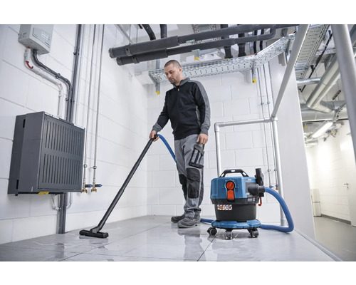 Man zuigt een kamer met een nat- en droogzuiger