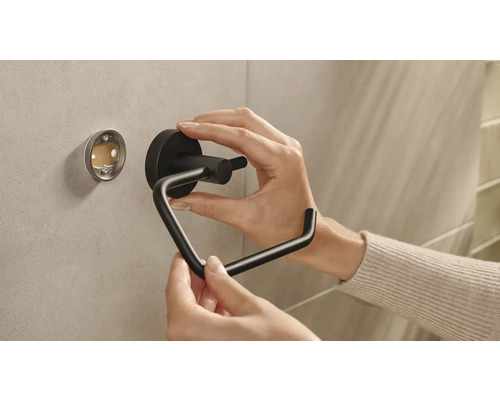 Installatie van een zwarte toiletpapierhouder aan de muur