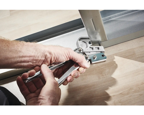 Handen gebruiken een perforatietang op een metalen profiel