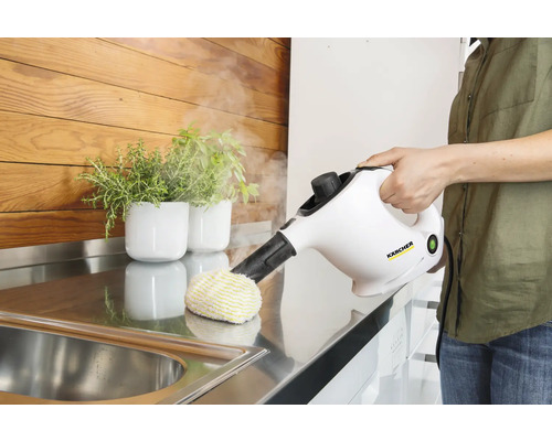 Stoomreiniger in gebruik op een werkblad met spoelbak en planten