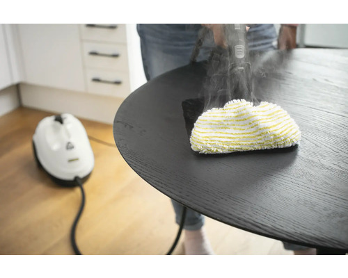 Stoomreiniger in gebruik op een ronde tafel voor reiniging