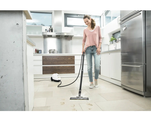 Vrouw reinigt keukenvloer met stoomreiniger