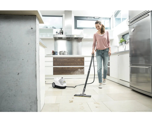 Vrouw reinigt keukenvloer met een stoomreiniger van Kärcher