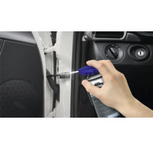 Een persoon spuit multifunctionele olie op het deurscharnier van een auto.