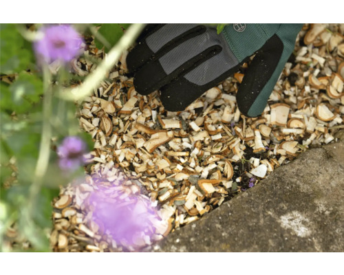 Close-up van houtsnippers, tuinhandschoenen en plant