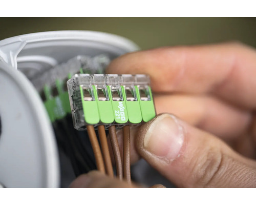 Detailopname van een man die elektrische leidingen verbindt met een Wago 221-klem