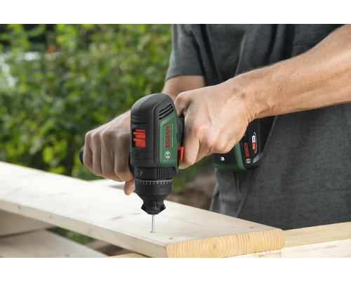 Man schroeft schroef in een houten plank met een Bosch accuschroevendraaier