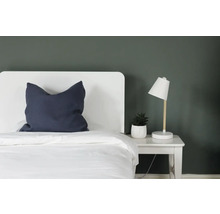 Slaapkamer met bed, nachtkastlamp en kamerplant