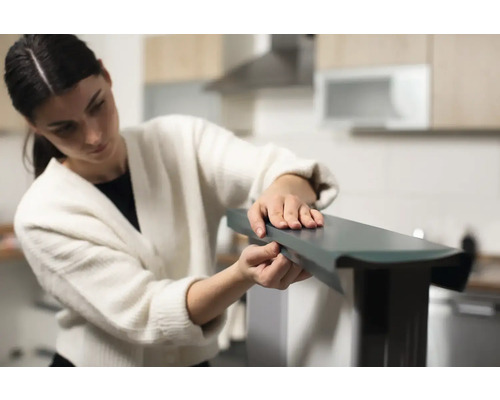 Vrouw monteert meubelstuk in keuken