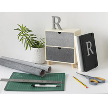 Decoratieve scène met ladekast, plant, notitieboek, snijmat, rollen en gereedschap
