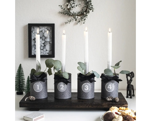 Adventsstuk met vier kaarsen en decoraties op een donkerhouten dienblad.