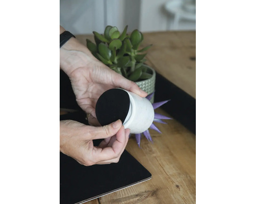 Decoratieve bloempot met viltjes wordt op een tafeloppervlak geplaatst.