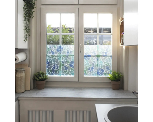 Raam met decoratieve raamfolie in bloemmotief voor meer privacy.