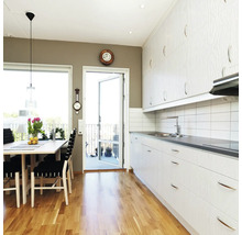 Lichte keuken met eettafel en toegang tot balkon.