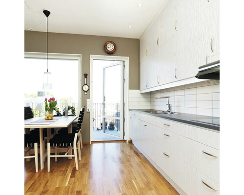 Lichte keuken met eethoek, houten vloer en toegang tot het balkon.