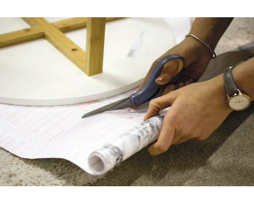 Decoratieve folie knippen met een schaar voor een tafel