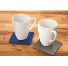 Twee witte mokken op onderzetters op een houten tafel.