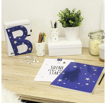 Decoratieve schikking met brief, pennen, notitieboek en plant op een tafel