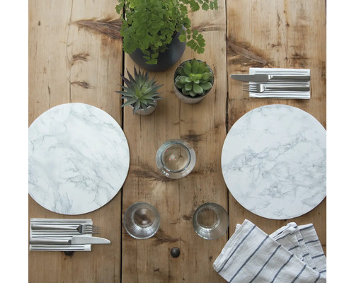 Decoratieve tafel met marmeren placemats, bestek, glazen en potplanten