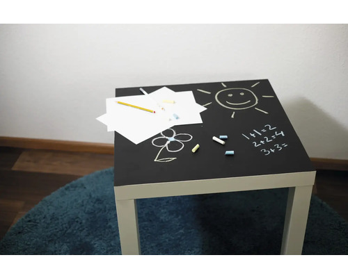 Kindertafel met krijtoppervlak, krijttekeningen, papier en potlood