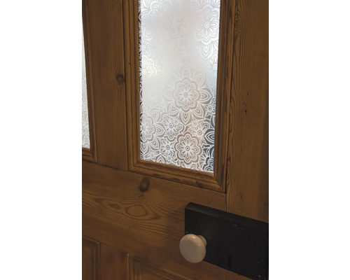 Houten deur met bloemmotiefglas en een deurknop