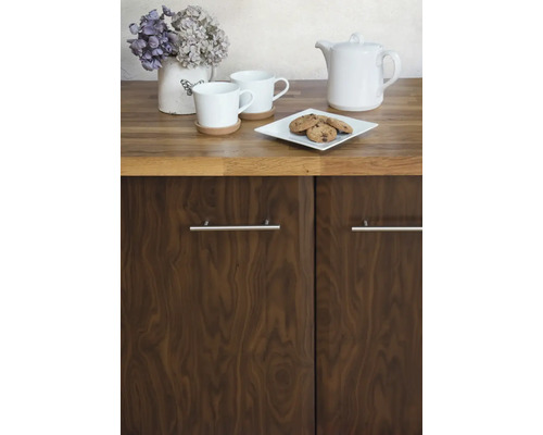 Keukenscène met servies, gebak en bloemdecoratie op een aanrecht boven een kast