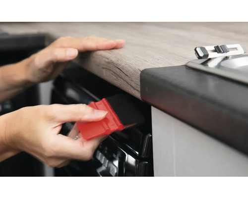 Gebruik van een rakel om folie op een kookplaat glad te strijken