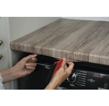 Decoratieve folie in houtlook wordt op een tafel bevestigd
